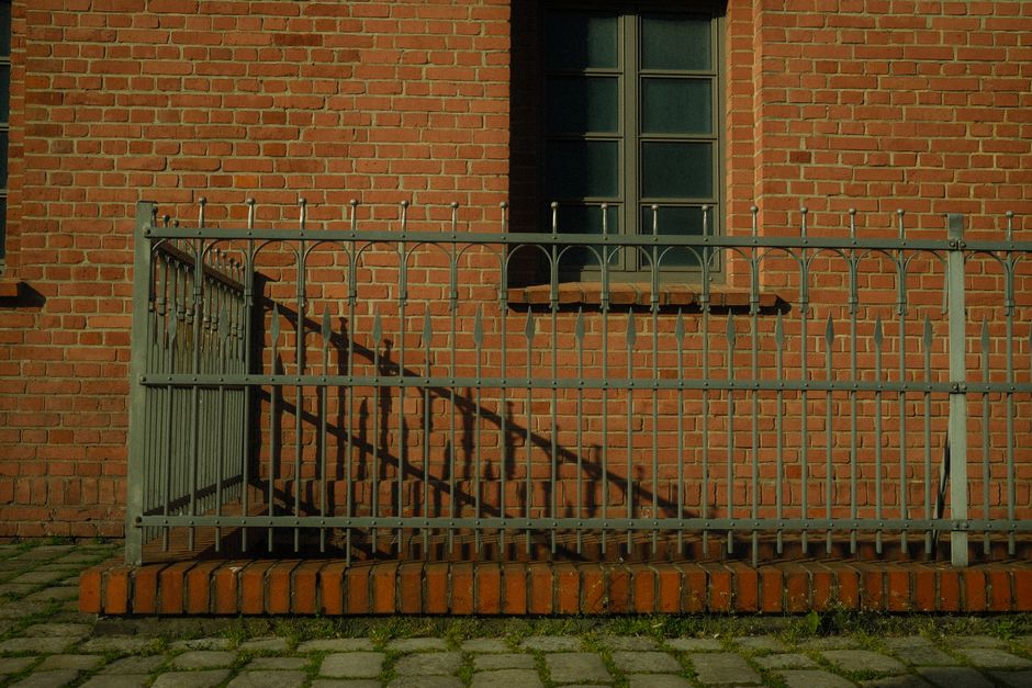 Metal railing fence with vertical bars along brick steps
