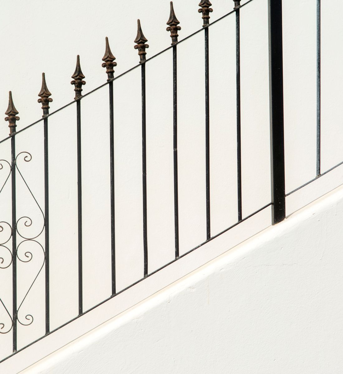 Black ornamental metal fence with spear-top pickets